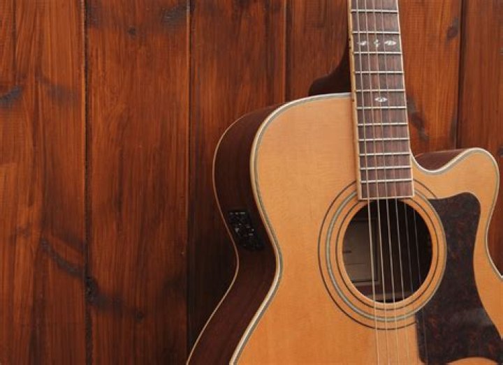 How do you adjust the intonation on an acoustic guitar?