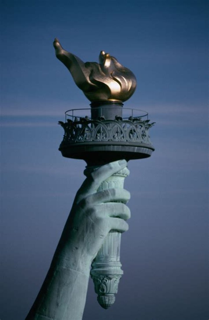 What does the Statue of Liberty hold in each hand?